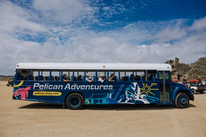 a blue bus parked in front of a truck