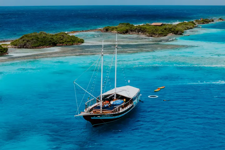 a blue and white boat sitting next to a body of water