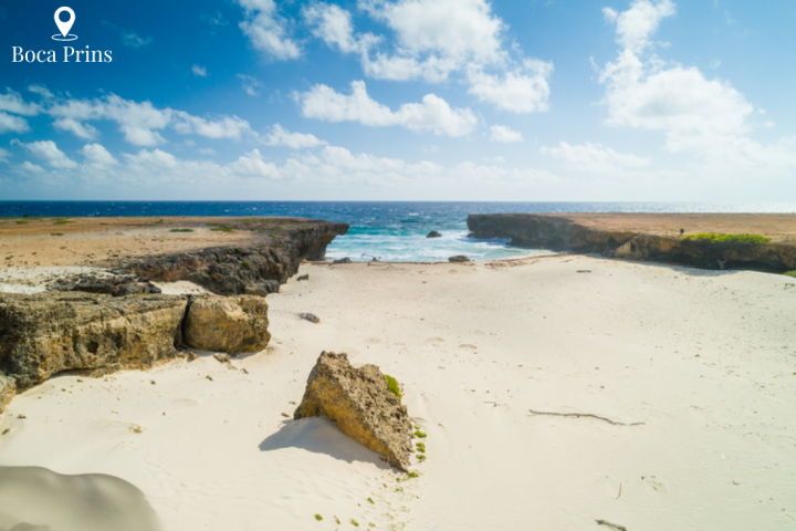 a sandy beach next to a body of water