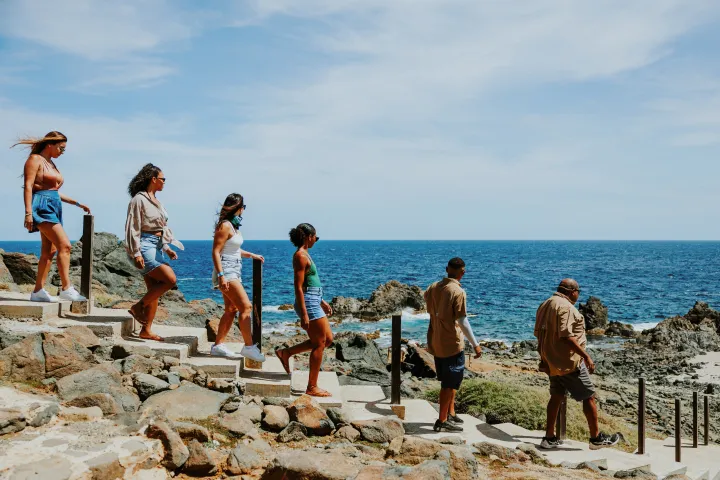 a group of people standing on a rocky beach