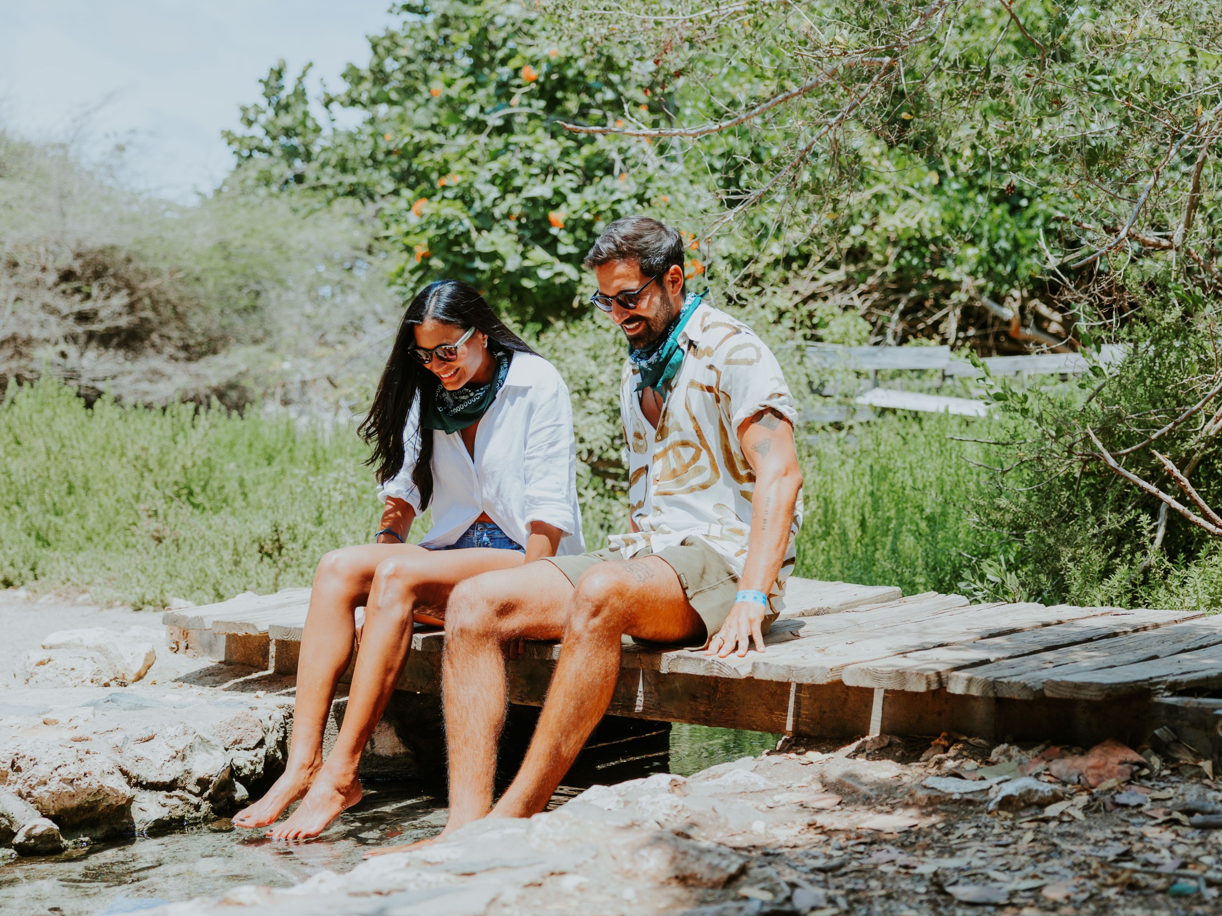 a man sitting next to a body of water