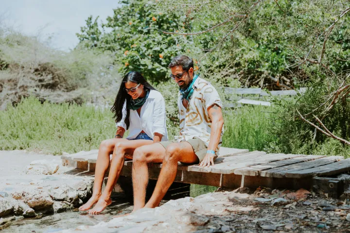 a man sitting next to a body of water