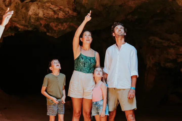a man and a woman standing in front of a cave