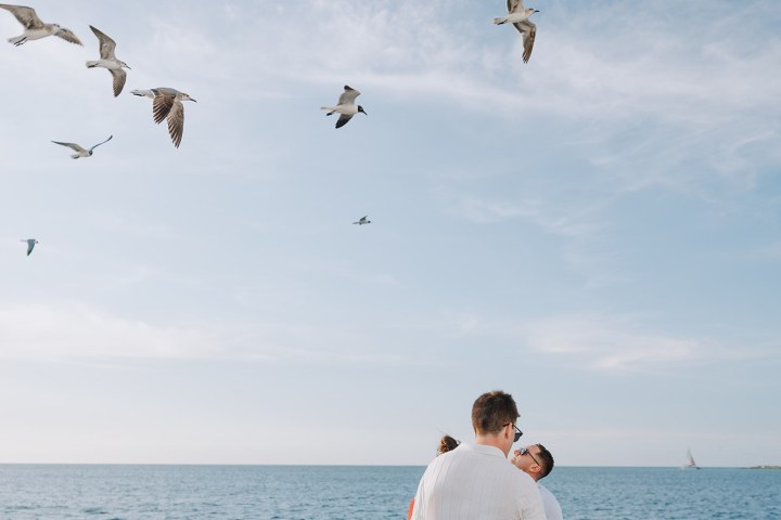 a group of people flying kites in a body of water