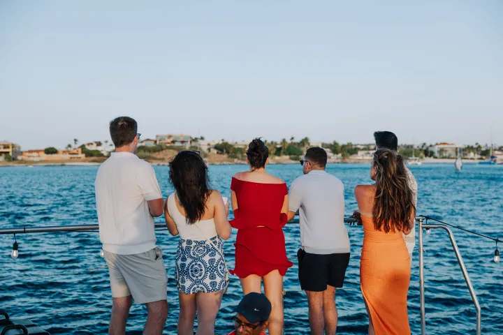 a group of people standing next to a body of water