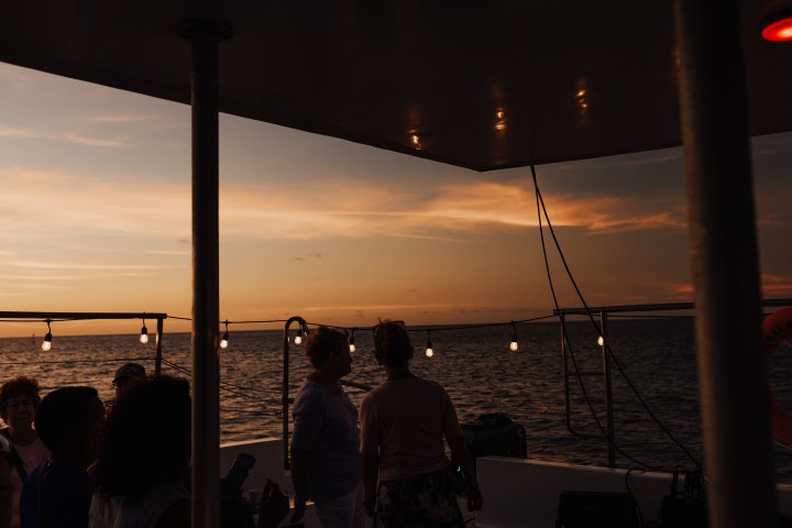 a group of people standing next to a body of water